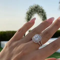 A cushion halo diamond ring worn outdoors.